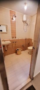a bathroom with a toilet and a sink at Royal Black Pepper Cottage in Yercaud