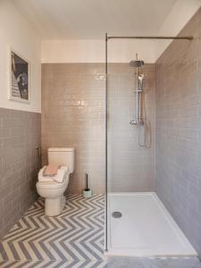 a bathroom with a toilet and a glass shower stall at Hegyi Kabin - Zebegény in Zebegény +12 photos