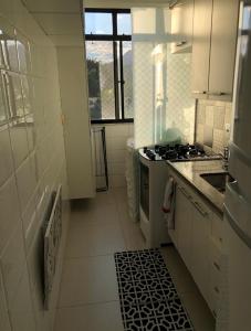 cocina blanca con fogones y fregadero en Casa Mag :) en Río de Janeiro