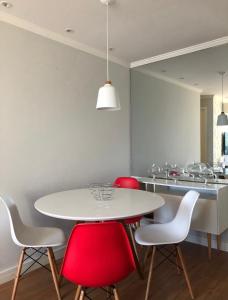cocina con mesa blanca y sillas rojas en Casa Mag :), en Río de Janeiro