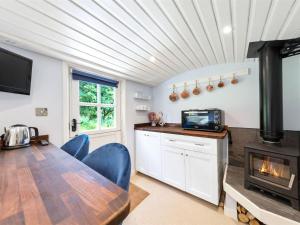 a kitchen with a wooden table and a fireplace at The Clarence in Doddington