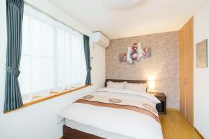 ein Schlafzimmer mit einem Bett und einem großen Fenster in der Unterkunft Luxury Guest House in Tokyo Shinjuku in Tokio