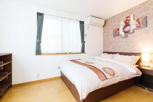 a bedroom with a large bed and a window at Luxury Guest House in Tokyo Shinjuku in Tokyo