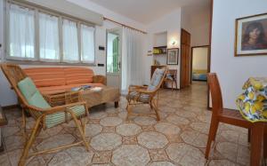 ein Wohnzimmer mit einem Sofa, einem Tisch und Stühlen in der Unterkunft Villa Stefania in Lignano Sabbiadoro