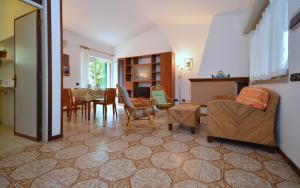 ein Wohnzimmer mit einem Sofa, Stühlen und einem Tisch in der Unterkunft Villa Stefania in Lignano Sabbiadoro