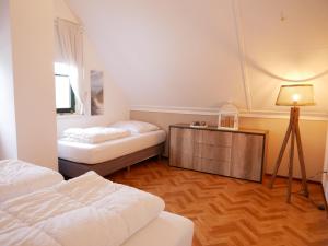 a room with two beds and a table with a lamp at Buitenplaats 5-p in Callantsoog