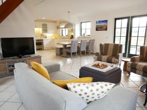 a living room with a couch and a tv at Buitenplaats 5-p in Callantsoog
