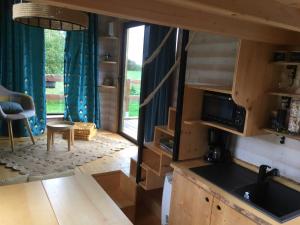 cocina y sala de estar con ventana grande en La Tiny Breizh, en La Poëtevinière