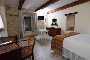Habitación de hotel con cama, escritorio y mesa. en B&B La Torretta, en Bitritto