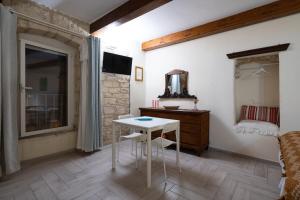 Habitación con mesa, cama y espejo. en B&B La Torretta, en Bitritto
