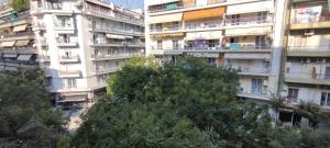 un grand immeuble avec des arbres devant lui dans l'établissement Kelly's Luxury Suite in Thessaloniki's Center, à Thessalonique