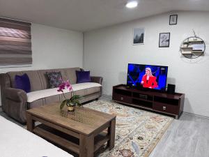ein Wohnzimmer mit einem Sofa und einem TV in der Unterkunft Apartman Centar in Novi Pazar