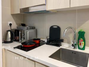 una cucina con lavandino e piano cottura forno superiore di Comfort Pool View Studio 5PX Near Mid Valley a Kuala Lumpur