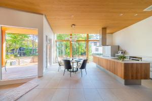 a kitchen and dining room with a table and chairs at Ren chalet in Hakuba
