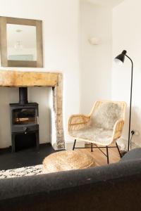 a living room with a chair and a fireplace at Charming 2BD Cottage wIth beautiful views nr Bath in Batheaston