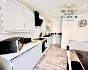 a kitchen with white cabinets and a counter top at Monthly Stays Liverpool in Liverpool