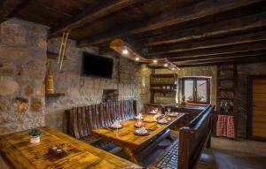 een eetkamer met houten tafels en een stenen muur bij Antini dvori in Imotski