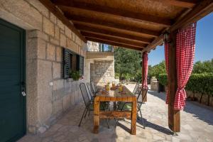 Une table et des chaises en bois sont disponibles sur la terrasse. dans l'établissement Antini dvori, à Imotski