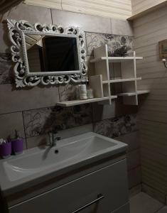 uma casa de banho com um lavatório e um espelho na parede em Lavender House em Slavske