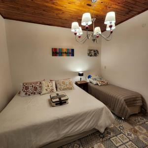 1 dormitorio con 2 camas y lámpara de araña en CASABLANCA APARTAMENTOS en San Roque