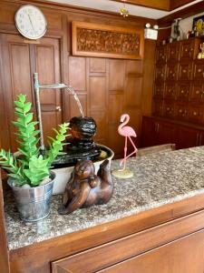 a kitchen counter with a bird and a clock and a plant at Baan Sudarat Hotel in Patong Beach