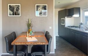 a dining room table with black chairs and a kitchen at Stunning Home In Scherpenisse in Scherpenisse