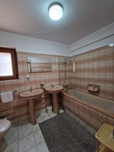 a bathroom with two sinks and a tub at Pensiunea Irina in Vama