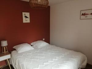 um quarto com uma grande cama branca em Maison Jullouville au calme em Jullouville-les-Pins