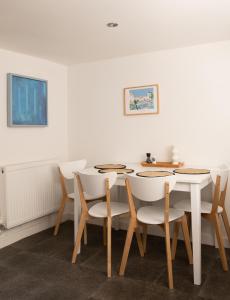 a dining room with a white table and chairs at Charming 2BD Cottage wIth beautiful views nr Bath in Batheaston
