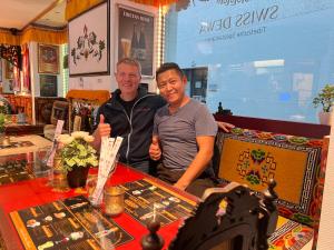 two men giving a thumbs up at a table at Swiss Dewa in Lucerne