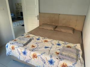 a bed with a floral comforter and a book on it at NAPOLİ REZiDANCE in Kahramanmaraş