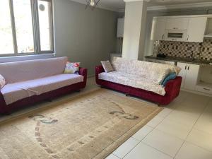 una sala de estar con 2 sofás y una alfombra en NAPOLİ REZiDANCE, en Kahramanmaraş