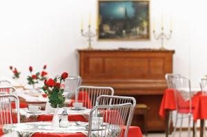 ein Esszimmer mit roten Tischen und einem Klavier in der Unterkunft Hotel Viktoria Schönbrunn in Wien