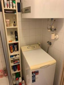 a small kitchen with a white refrigerator and a shelf at Kleine Wohnung im Zentrum Graz in Graz