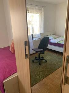 um quarto com uma cadeira, uma cama e uma janela em Kleine Wohnung im Zentrum Graz em Graz