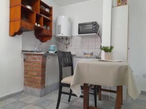 een keuken met een tafel, 2 stoelen en een wastafel bij CELESTINA in Cordoba
