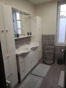 Baño con 2 lavabos y espejo en Maison chez fredo, en Calais