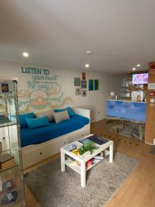 a living room with a blue couch and a table at Hostel Eleven in Esposende