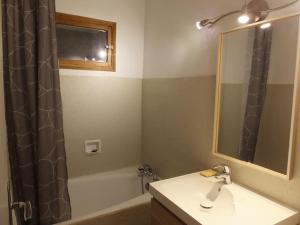 a bathroom with a sink and a shower curtain at Appartement T4 cosy et familial en bord de pistes in Puy-Saint-Pierre