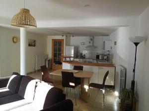 a living room with a couch and a table and a kitchen at Appartement T4 cosy et familial en bord de pistes in Puy-Saint-Pierre