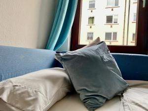 a pillow sitting on a couch next to a window at Ruhige Innenstadtlage mit Terrasse und Netflix in Kassel