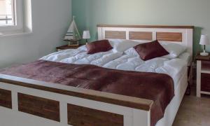 a bedroom with a large white bed with two pillows at 5 Sterne Penthouse DeichSuite in Büsum