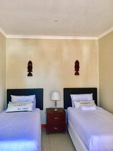 two beds sitting next to each other in a bedroom at Lamamie guest house in Thohoyandou