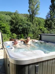 duas crianças a nadar numa banheira de hidromassagem em Gîte et chambres d'hôtes LE MERCOIRE em Aubenas