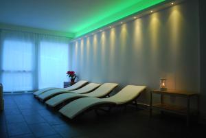 een rij banken in een kamer met groene verlichting bij Hotel Elbele Garnì in Folgaria