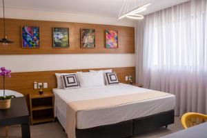 1 dormitorio con 1 cama grande y 1 mesa en Porto das Asas Park Hotel, en Andradas