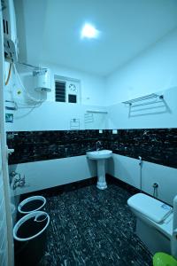 uma casa de banho com um lavatório, um WC e uma luz azul em RK MOUNT ORCHID coorg em Madikeri