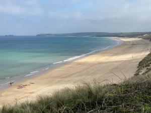 a beach with people on the sand and the ocean at Surfside in Hayle