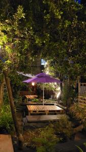a picnic table with an umbrella in a garden at night at Laughing Buddha Guest House & Villa in Kathmandu