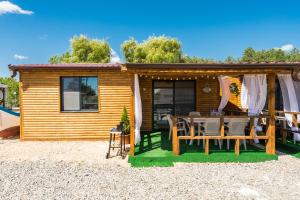 a cabin with a table and chairs in front of it at ECO Hоuses - Camping Gradina in Chernomorets